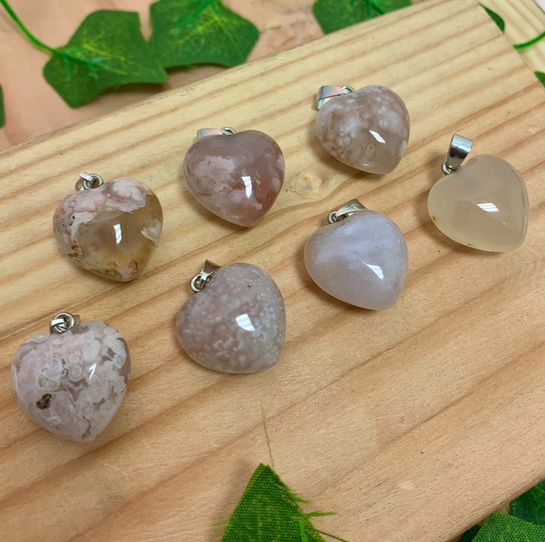 Puede incluir: Siete colgantes de &aacute;gata en forma de coraz&oacute;n con un aro de plata. Los colgantes son de varios tonos de blanco, gris y rosa con patrones de &aacute;gata marr&oacute;n y blanco.