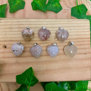 Puede incluir: Siete colgantes de &aacute;gata en forma de coraz&oacute;n con un aro de plata. La &aacute;gata es de color rosa claro y blanco con un patr&oacute;n nublado.