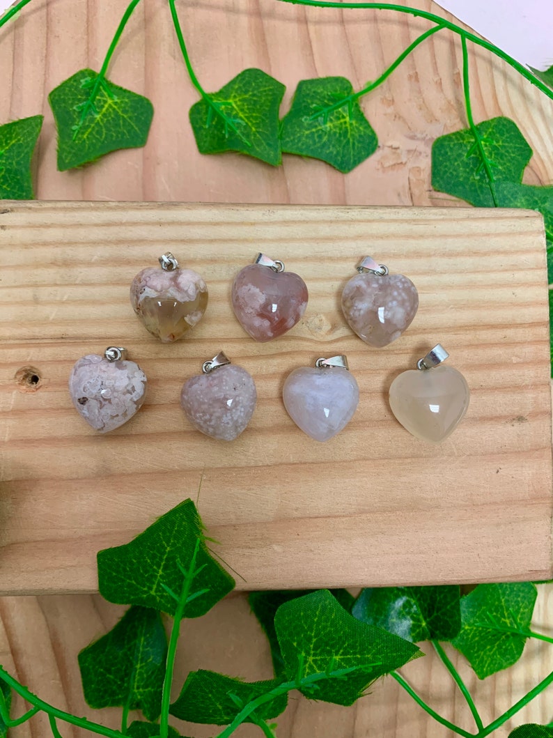 Puede incluir: Siete colgantes de &aacute;gata en forma de coraz&oacute;n con un aro de plata. La &aacute;gata es de color rosa claro y blanco con un patr&oacute;n nublado.