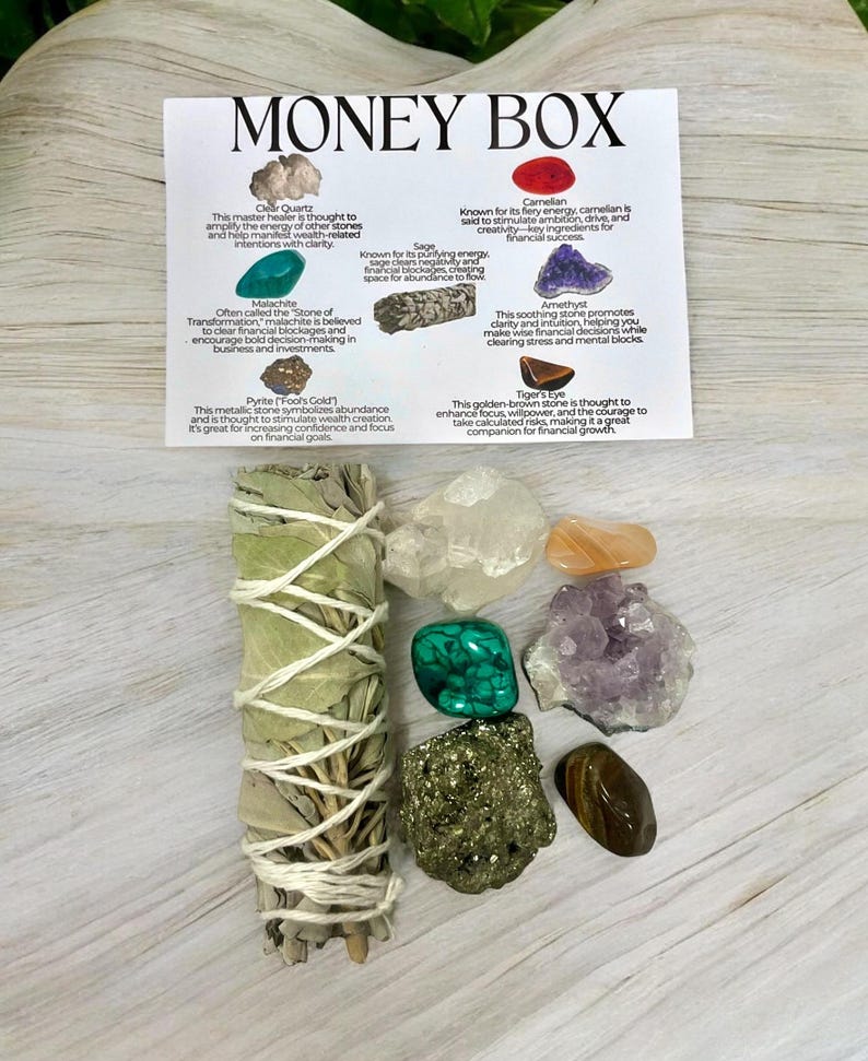 Peut inclure: Un kit de bo&icirc;te &agrave; argent avec divers cristaux, dont du quartz clair, de la malachite, de la pyrite, de la cornaline, de l'am&eacute;thyste, de l'&oelig;il de tigre et de la sauge. Le kit comprend &eacute;galement un b&acirc;tonnet de sauge blanche.