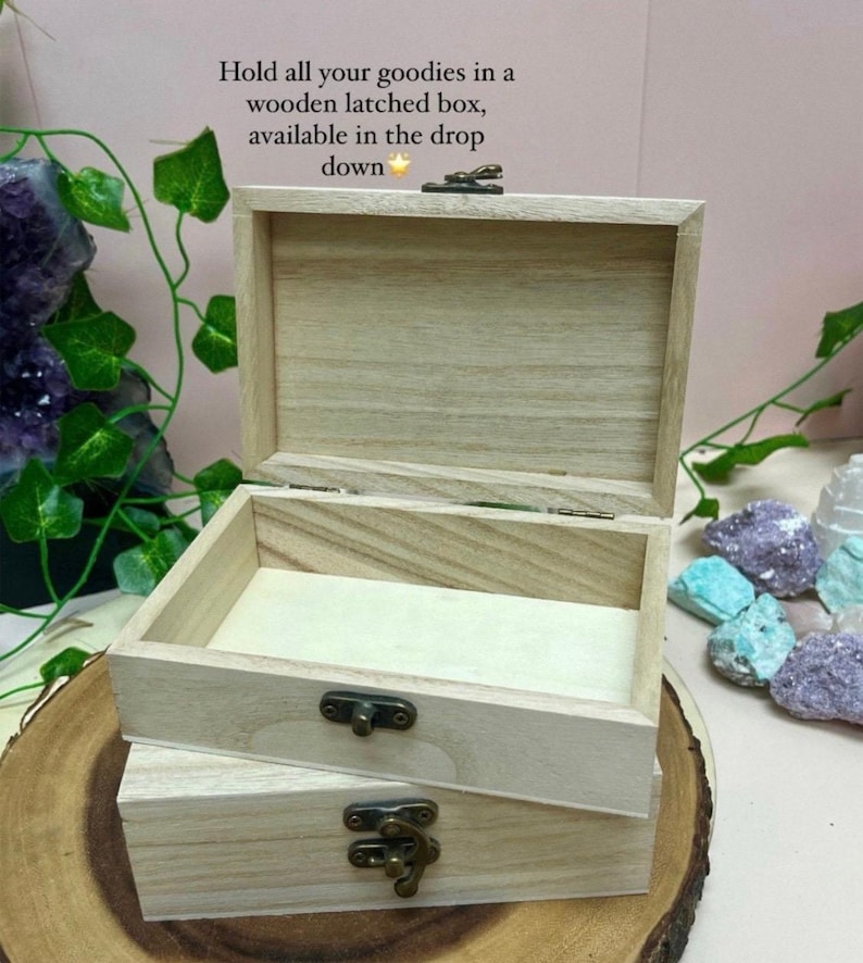 Peut inclure: Une bo&icirc;te en bois avec un loquet et un couvercle &agrave; charni&egrave;res. La bo&icirc;te est en bois clair et a une finition naturelle. La bo&icirc;te est pos&eacute;e sur une surface en bois.