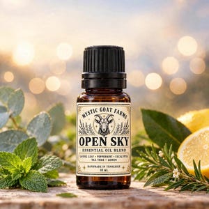 May include: A 10 mL amber glass bottle of Mystic Goat Farms Open Sky essential oil blend with a black cap. The label features a goat illustration, the text Open Sky, and lists laurel leaf, peppermint, eucalyptus, tea tree, and lemon ingredients.