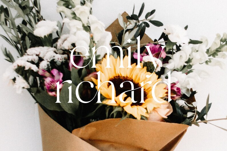 May include: A bouquet of flowers in brown paper wrapping, including white and purple flowers, and a large yellow sunflower. The text "emily richard" is written in white script over the flowers.