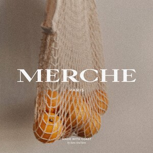Peut inclure: Un sac en filet blanc avec des oranges &agrave; l'int&eacute;rieur. Le sac est suspendu en haut de l'image. Le texte "MERCHE PARIS" est en lettres blanches sur un fond beige. En dessous du texte se trouve le texte "MADE WITH COAST by Sons of Sons".