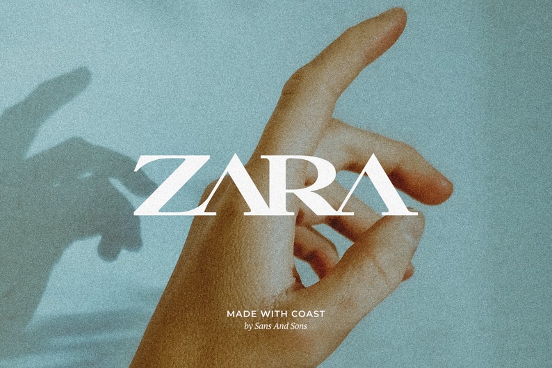 Peut inclure: Un logo en texte blanc qui lit "ZARA" avec le texte "MADE WITH COAST by Sans And Sons" en dessous. Une main pointe vers le haut avec l'ombre d'une main en arri&egrave;re-plan.