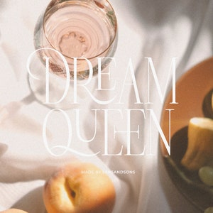 May include: A white background with a glass of pink liquid, a peach, a lemon, and a plate of grapes. The text "DREAM QUEEN" is written in white on the background. The text "MADE BY SANDSONS" is written in white below the text "DREAM QUEEN".