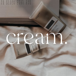 May include: Two tubes of cream on a white fabric background. The tubes are labeled "Skincare Cleanser" and "Moisturizing Serum". The word "cream." is written in white text on the fabric.