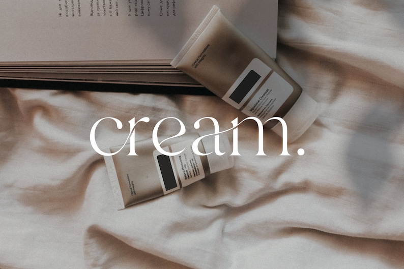 May include: Two tubes of cream on a white fabric background. The tubes are labeled "Skincare Cleanser" and "Moisturizing Serum". The word "cream." is written in white text on the fabric.