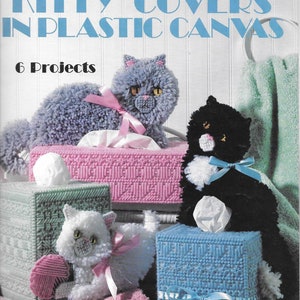 Puede incluir: Seis patrones de cubiertas para cajas de pañuelos con gatitos de varios colores. Los patrones están hechos con lona de plástico e incluyen una cubierta para caja de pañuelos azul, rosa y verde. El título del libro de patrones es "Kitty Covers in Plastic Canvas" y el subtítulo es "6 Projects".