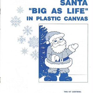 May include: A craft kit for making a large Santa Claus figure. The kit includes acrylic yarn, plastic canvas, a needle, a pattern chart, and instructions. The image shows a cartoon Santa Claus with a white beard and a blue suit.