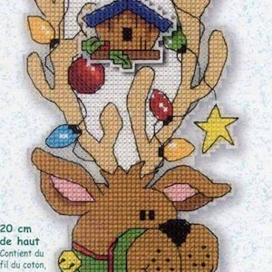 May include: A cross-stitch pattern featuring a reindeer with a red bow, green holly, and gold bells. The reindeer has a house on its antlers with lights strung around it. The pattern is 8 inches long and includes cotton thread, plastic canvas, a needle, and easy instructions.