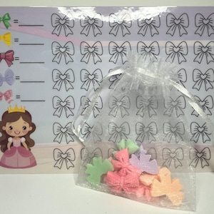 May include: A children's educational game featuring a princess illustration and colorful bow-shaped counters. The game board has bow outlines for matching, with a clear bag containing assorted pastel-colored bows.