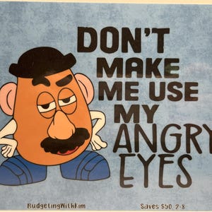 May include: A blue and white sign with a cartoon image of Mr. Potato Head with the text "Don't make me use my angry eyes".