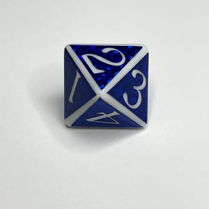Puede incluir: Un dado D4 azul y blanco con los números 1, 2, 3 y 4. El dado tiene una superficie azul brillante y números blancos. El dado es un dado de cuatro caras, comúnmente utilizado en juegos de mesa.