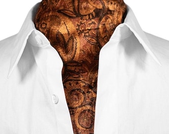 May include: A brown ascot with a paisley pattern is worn with a white dress shirt. The ascot features a detailed design in shades of brown and black. The white shirt has a classic collar and button closure.