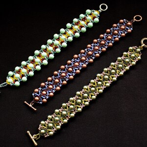 May include: Three beaded bracelets with different colored beads and patterns. The bracelets are made with green, brown, and blue beads. The bracelets have clasps on the ends.