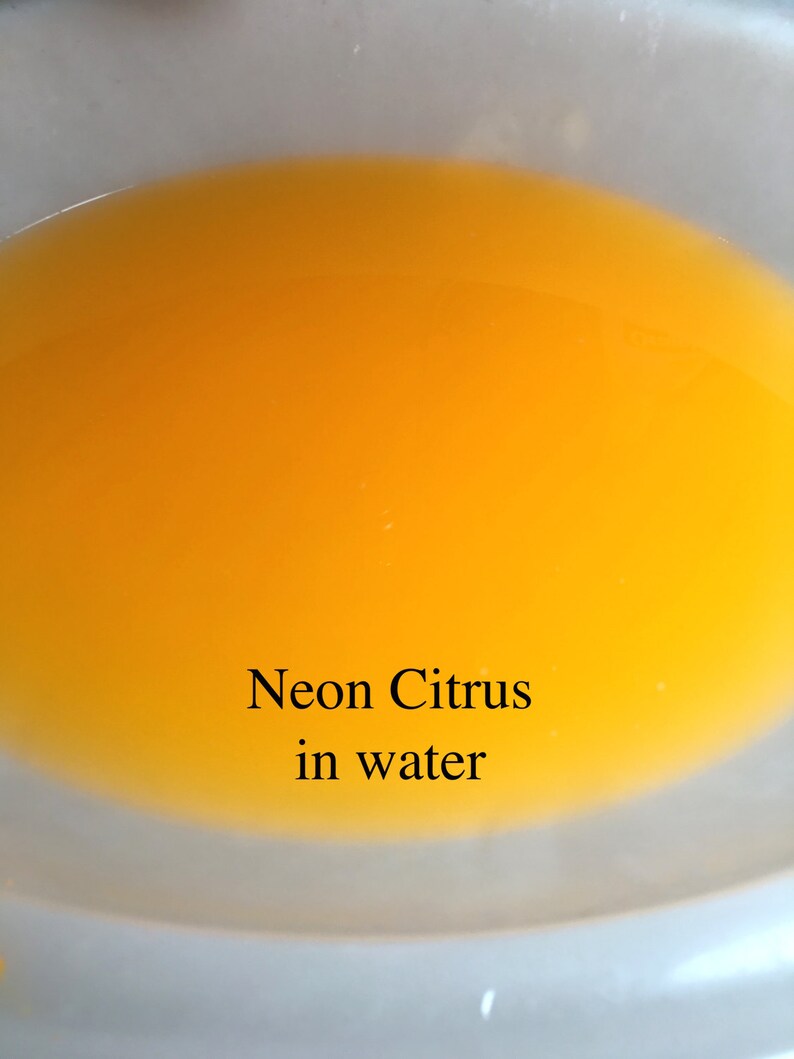 May include: A close-up of a clear bowl filled with bright yellow liquid. The text "Neon Citrus in water" is written below the bowl.