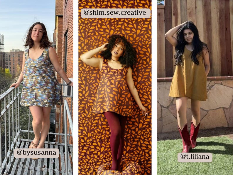 May include: Three women wearing different dresses. The woman on the left is wearing a blue and green patterned dress. The woman in the middle is wearing a brown dress with a leaf pattern and maroon tights. The woman on the right is wearing a brown dress and brown boots. The background behind the women is a brick wall, a brown and orange leaf pattern, and a wooden fence.