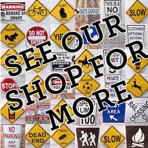 May include: A collection of colorful metal signs with various warnings, messages, and symbols. The signs are arranged in a grid pattern and feature phrases like "See Our Shop For More", "Warning Beware of Owner", "Do Not Enter", "Cat", "Dad's Garage", "This is a No Whining Zone", "Slow", "Squirrel", "Yif", "Hell With The Dog Beware of Owner", "Clothing Optional Beyond", "Stop", "Soccer", "Private Property", "Reserve Parking Your Text Here", "Speed Limit 100", "No Parking Any Time", "Dead End", "Disc", "Trail Area", "Slow", "Railroad Crossing", and "Warning You're Ex".