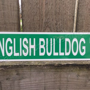 May include: Green metal sign with white text that reads "ENGLISH BULLDOG PL".
