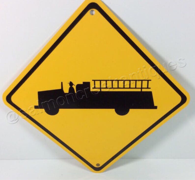 May include: Yellow diamond-shaped road sign with a black silhouette of a fire truck with a ladder on top. The sign warns drivers to be aware of fire trucks.