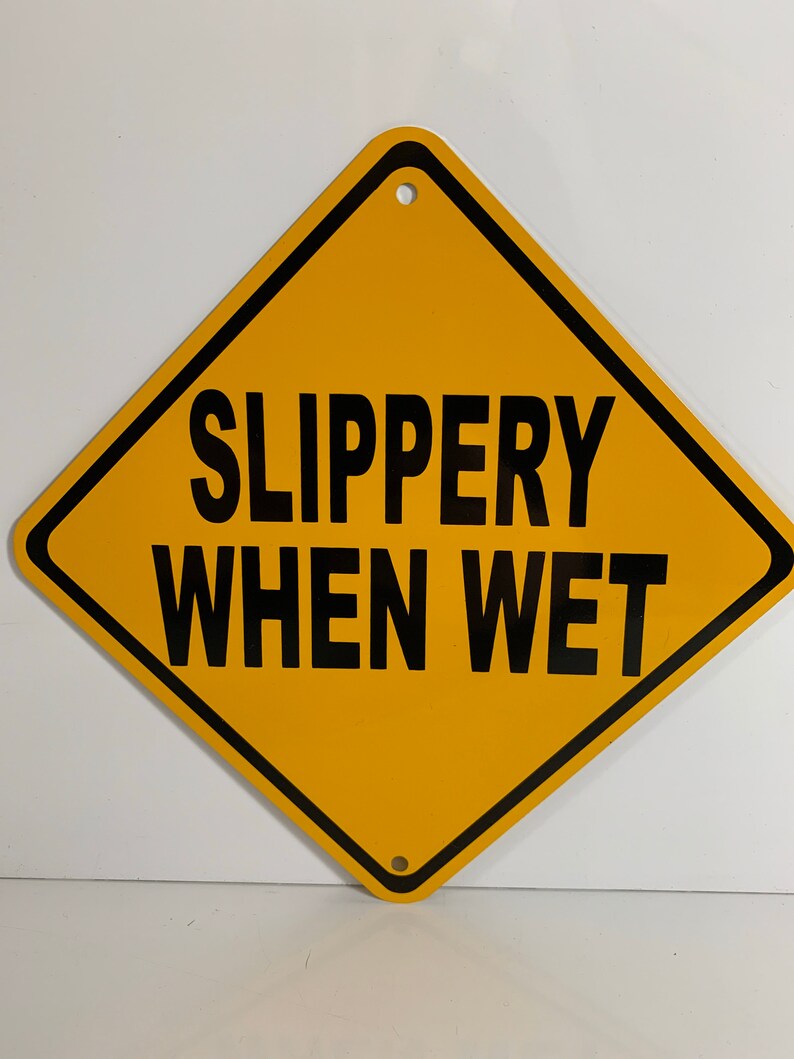 May include: Yellow diamond-shaped warning sign with black border and text that reads "SLIPPERY WHEN WET".