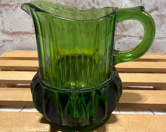 Jarra para crema/palillero de vidrio prensado EAPG vintage de color verde esmeralda con cuerpo acanalado y base en forma de estrella.