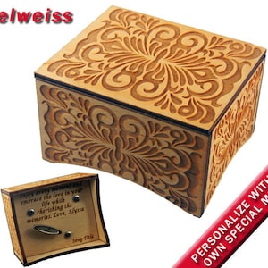 May include: A wooden music box with an intricate floral design. The box is closed and has a small plaque on the side with the text "Enjoy every moment and embrace the love in your life while cherishing the memories. Love, Alyssa". The box is personalized with the text "PERSONALIZE WITH YOUR OWN SPECIAL MESSAGE".