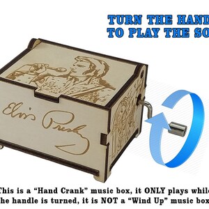 K&ouml;nnte beinhalten: Eine Holz-Musikbox mit einer Handkurbel. Die Box zeigt ein lasergraviertes Bild von Elvis Presley, der in ein Mikrofon singt. Der Text "Drehe die Kurbel, um das Lied abzuspielen" ist &uuml;ber der Box gedruckt. Der Text "Dies ist eine "Handkurbel"-Musikbox, sie spielt NUR, wenn die Kurbel gedreht wird, es ist KEINE "Aufzieh"-Musikbox" ist unter der Box gedruckt.