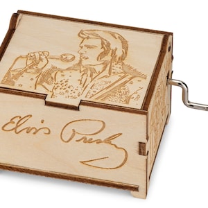 K&ouml;nnte beinhalten: Holz-Musikbox mit einem lasergravierten Bild von Elvis Presley, der in ein Mikrofon singt. Die Box hat eine Handkurbel an der Seite und die Unterschrift "Elvis Presley" ist auf der Unterseite graviert.