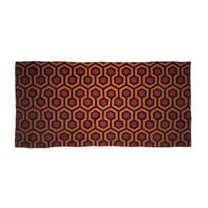 May include: A rectangular textile featuring a repeating geometric pattern. The design consists of interconnected hexagons and octagons in shades of orange, red, and black. The overall aesthetic is bold and graphic, suitable for home decor or fashion.