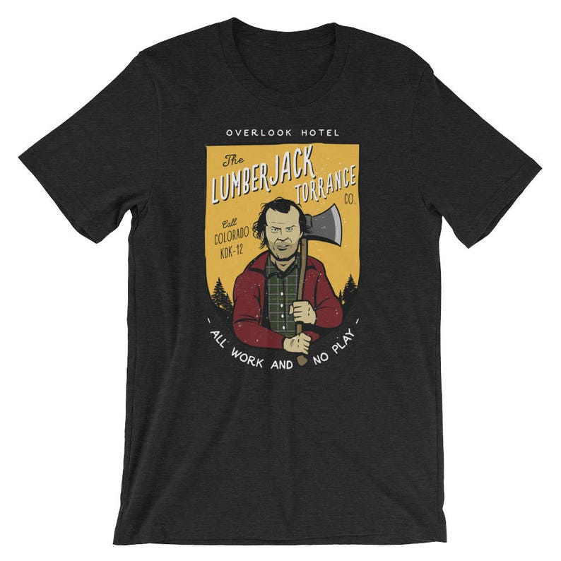 Może przedstawiać: Szary t-shirt z ż&oacute;łto-pomarańczową grafiką przedstawiającą mężczyznę trzymającego siekierę. Grafika zawiera napis "The Lumberjack Torrance Co." i "All Work and No Play".