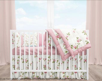 May include: A white cot with pink and white floral bedding, including a fitted sheet, a skirt, a comforter, and two pillows. The cot is in a room with pink curtains and a window with a view of a cloudy sky.