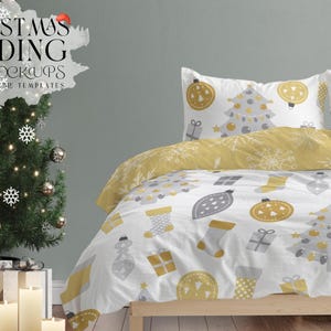 Puede incluir: Juego de cama navideño con un diseño festivo. La funda nórdica y las fundas de almohada presentan un fondo blanco con motivos de árbol de Navidad, adornos y regalos dorados y grises. Un árbol de Navidad con adornos y luces en el fondo.