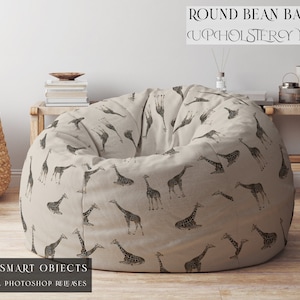 May include: A round bean bag chair with a beige fabric cover featuring a giraffe print. The chair is sitting in a living room setting with a wooden table and other decor.