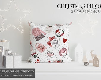 May include: A white cushion with a Christmas design, featuring illustrations of a pink cardigan, a calendar, and a wreath. The cushion is adorned with polka dots and the words "Merry Christmas". The image also shows star-shaped lights and gift boxes.
