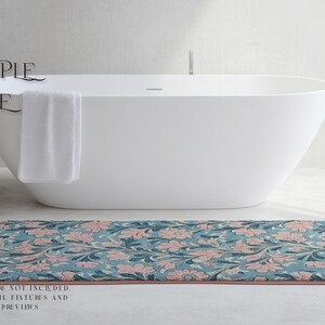 May include: A white bathtub with a blue and pink floral bath mat. The bath mat has a pink border.