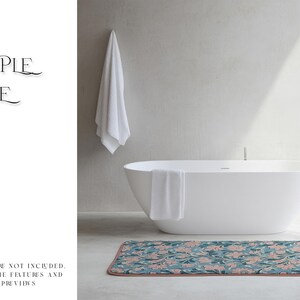 May include: A white bathtub with a white towel hanging over the side. The bathtub is sitting on a patterned bath mat with pink and green floral designs.