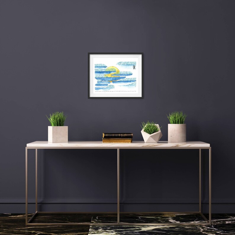 May include: A framed watercolour painting of a yellow sun behind blue and green clouds. The painting is hanging on a dark grey wall above a white marble console table with two potted plants.