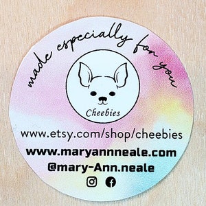 May include: A round sticker with a rainbow gradient background. The sticker features a black and white illustration of a dog with the text "Cheebies" below it. The text "made especially for you" is written in a circle around the dog illustration. The sticker also includes the text "www.etsy.com/shop/cheebies", "www.maryannneale.com", and "@mary-Ann.neale" along with Instagram and Facebook icons.