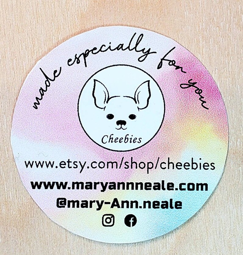 May include: A round sticker with a rainbow gradient background. The sticker features a black and white illustration of a dog with the text "Cheebies" below it. The text "made especially for you" is written in a circle around the dog illustration. The sticker also includes the text "www.etsy.com/shop/cheebies", "www.maryannneale.com", and "@mary-Ann.neale" along with Instagram and Facebook icons.