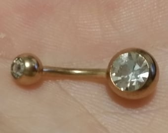 May include: Gold belly button ring with two clear crystal stones.