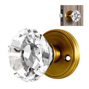 May include: A crystal door knob with a faceted design, mounted on a brass door plate.