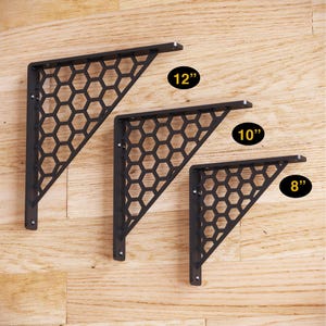 May include: Three black metal shelf brackets with a honeycomb design. The brackets are 8 inches, 10 inches, and 12 inches long.
