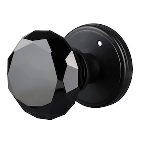 May include: Black door knob with a faceted glass crystal in the shape of a diamond. The knob is made of metal and has a black finish.