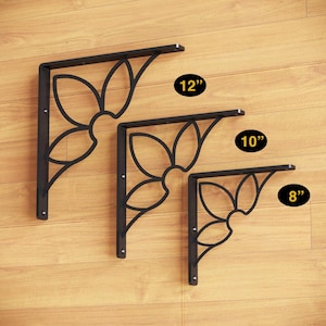 May include: Three black metal shelf brackets with a decorative floral design. The brackets are 8 inches, 10 inches, and 12 inches long.