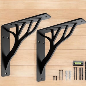 May include: Two black metal shelf brackets with a tree branch design. The brackets are mounted on a wood surface. The image also includes a level, screws, and anchors.