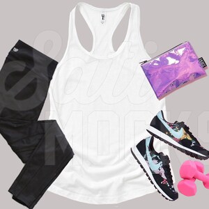 May include: A white tank top, black leggings, a pair of black and floral sneakers, a pink dumbbell set, and a holographic purple makeup bag.