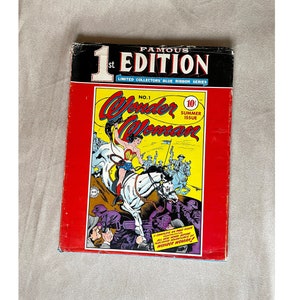Puede incluir: Una portada de cómic roja con el título "Famous 1st Edition" y "Limited Collectors' Blue Ribbon Series". La portada presenta a una mujer montando un caballo blanco con el texto "Wonder Woman" y "No. 1 Summer Issue 10¢".