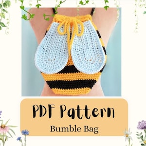 May include: A crochet drawstring backpack featuring a yellow and black striped body with two light blue textured wings attached to the front. The bag includes a yellow drawstring closure at the top. The text PDF Pattern Bumble Bag is visible.